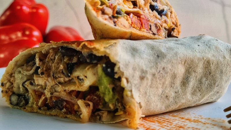 Wrap Piso Uno cortado al medio mostrando el relleno abundante, calidad premium que se defiende sola en el freezer del market