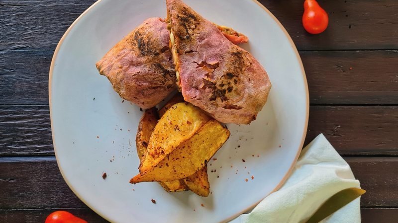 Plato de almuerzo premium servido en cafetería sobre mesa de madera oscura, el tipo de consumo que sube el ticket promedio